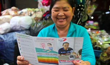 Woman reading in a flyer about blood pressure measurement