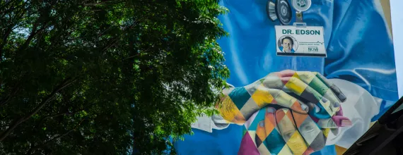 A grafitti on a house wall in Sao Paulo, Brazil showing an illustration of a health worker holding the hand of a patient