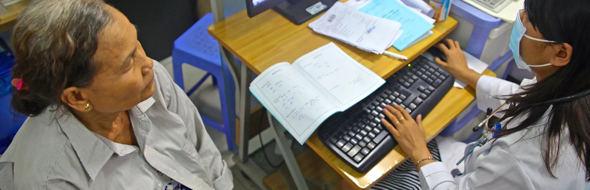 Female physician in front of a computer with female patient sitting opposite