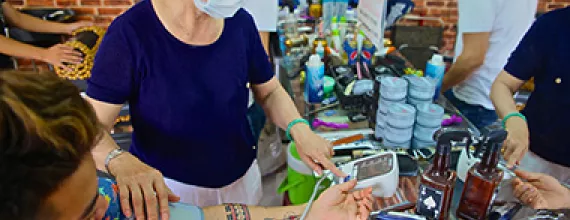 Woman measuring blood pressure Vietnam Woman wearing a mask measures blood pressure of a young man at a hair salon in Vietnam