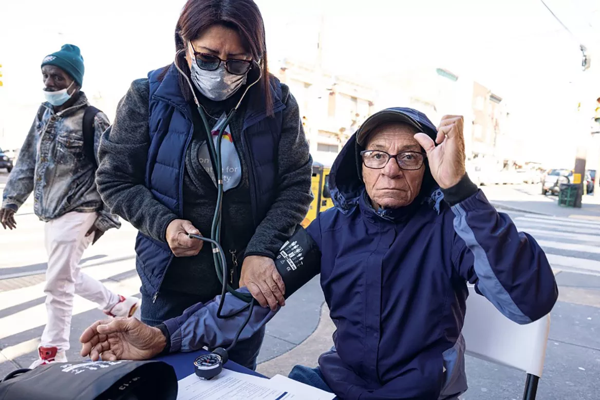 A healthworker takes a man's blood pressure as part of a hypertension management camapign in Philadelphia
