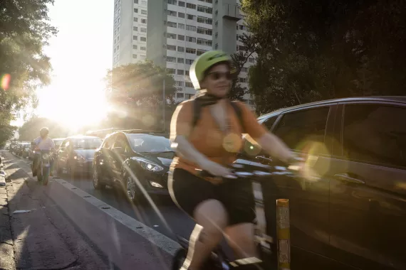 Woman cycling on street in Sao Paulo Woman cycling on a busy street in Sao Paulo