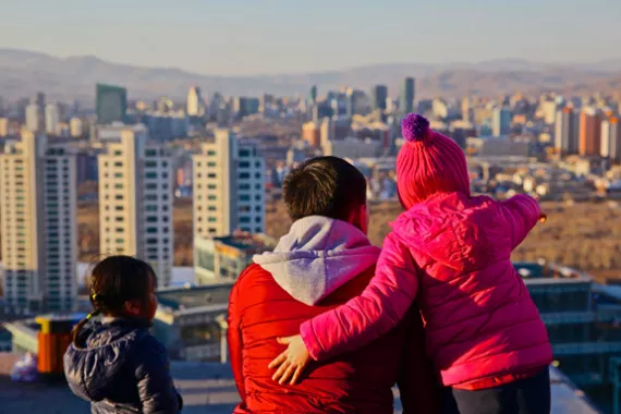 Man with children looking over the city of Ulaanbaatar