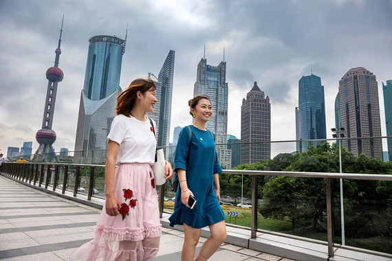 Two ladies walking in a modern city with the skyline in the background