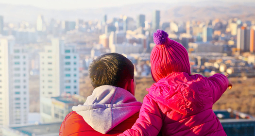 Father and daughter looking at a city skyline