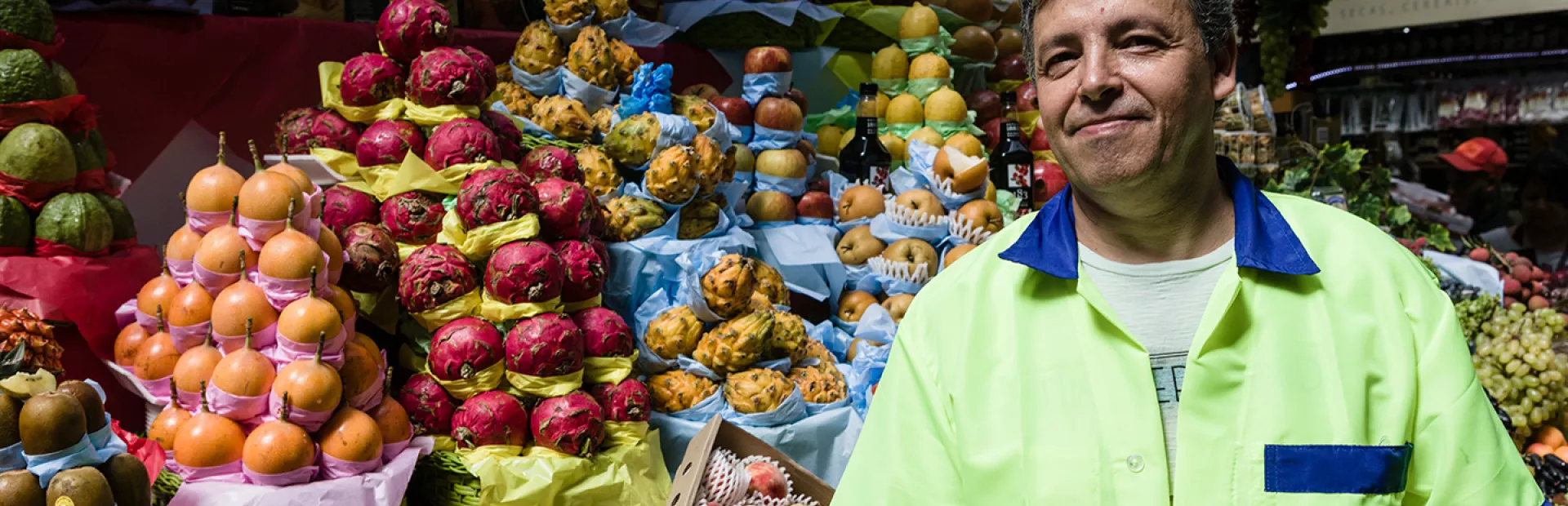 man standing infront of fruit stand_0