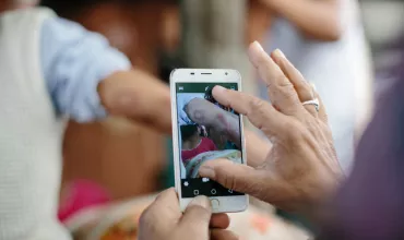 Person taking photo with its mobile phone of a leprosy lesion for AI-enabled and accelerated leprosy detection